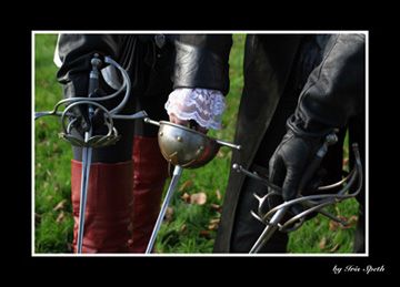 Gekreuzte Rapiere und Handschuhe zweier Musketiere